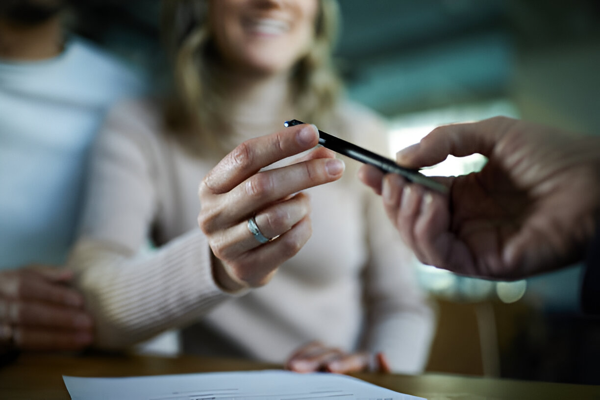 Personne donnant un stylo publicitaire à une cliente