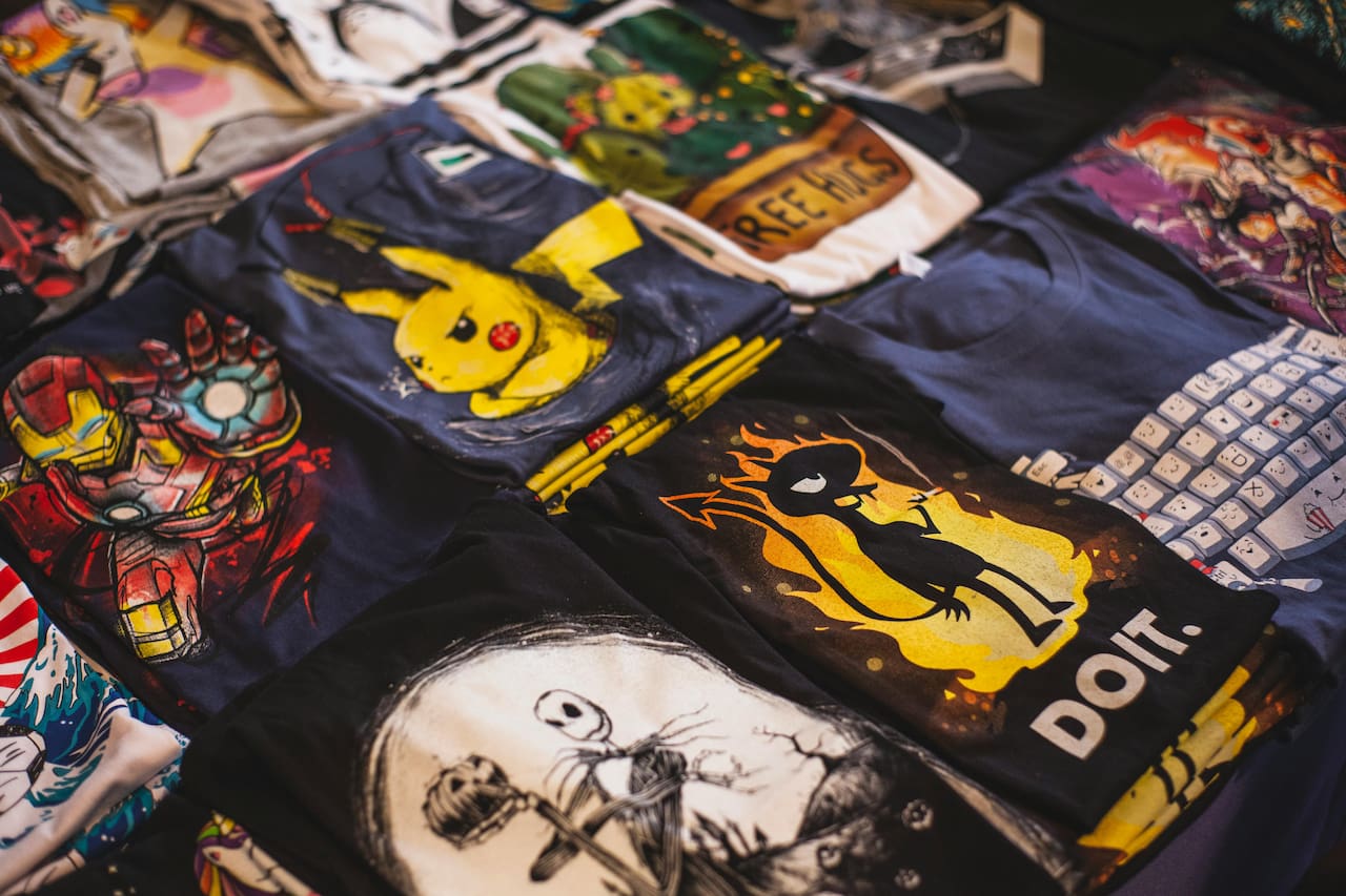 Exemples de t-shirts personnalisés avec impression textile et visuels colorés.